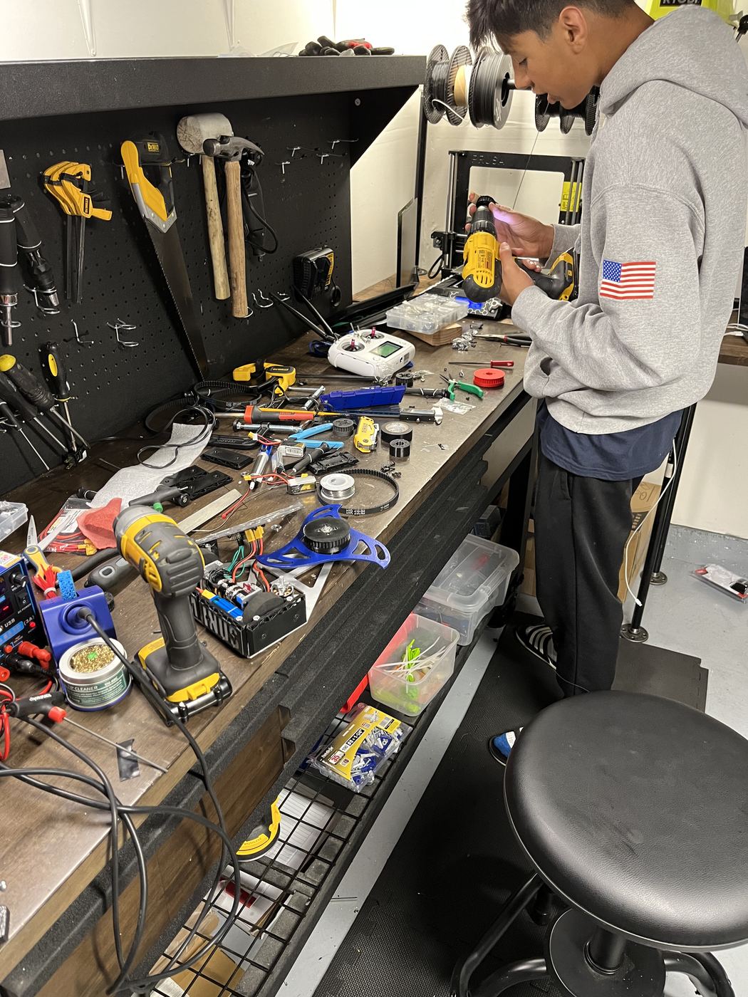 The workbench mid-build: printer, transmitter, drive components, and tools out.