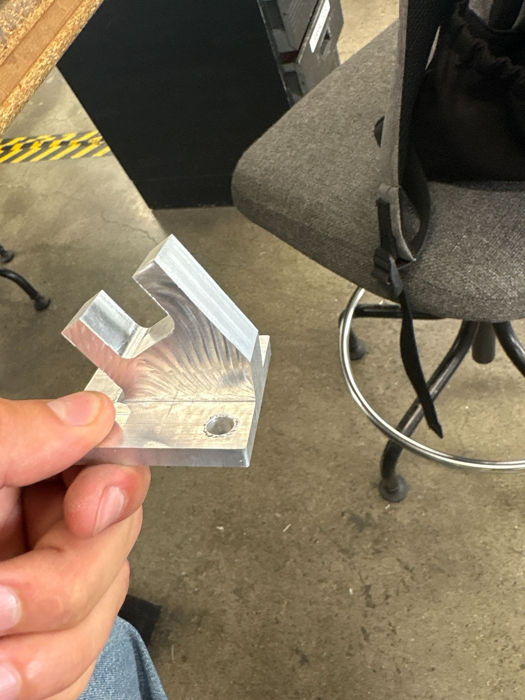 A finished machined aluminium bracket with the characteristic adaptive-clearing surface finish.
