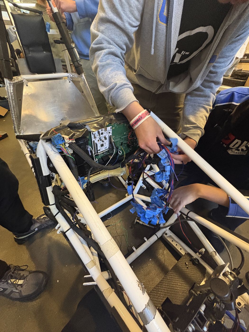 Wiring the low-voltage harness into the car's chassis.