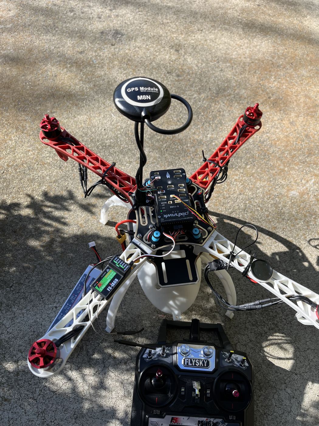 The assembled aircraft with Pixhawk flight controller, M8N GPS module, FS-iA6B receiver and the FlySky transmitter alongside.