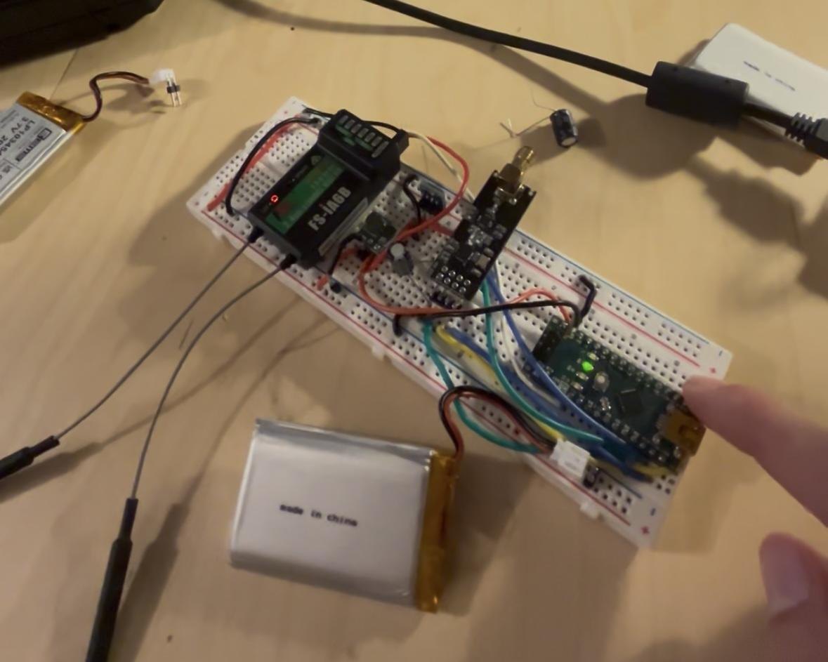 Airborne electronics: Arduino Nano, nRF24L01+ transceiver, and battery on the rectangular breadboard footprint the capsule was designed around.