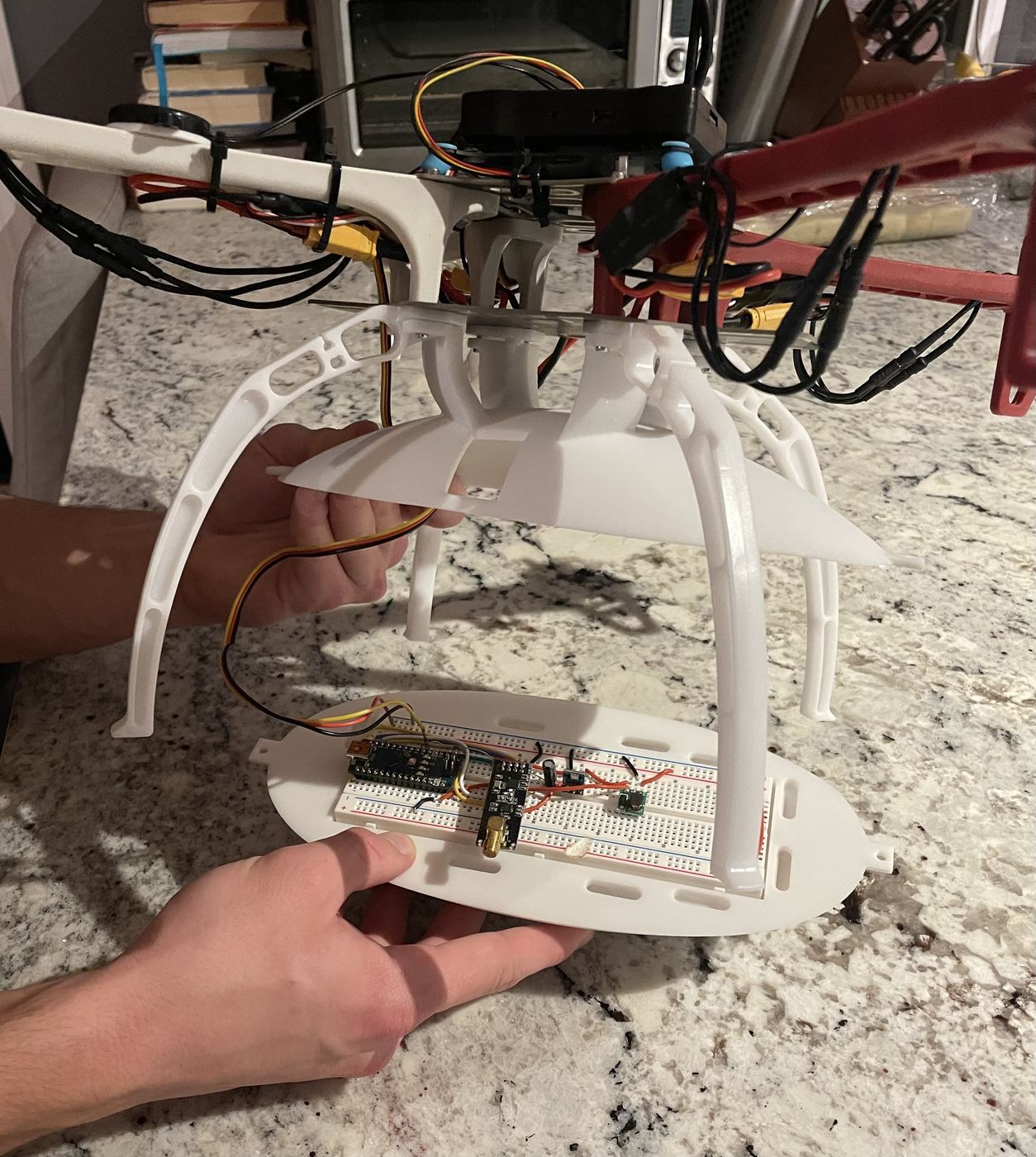 Fitting the lower capsule shell under the airframe, with the Arduino Nano and nRF24L01+ transceiver seated on the breadboard.