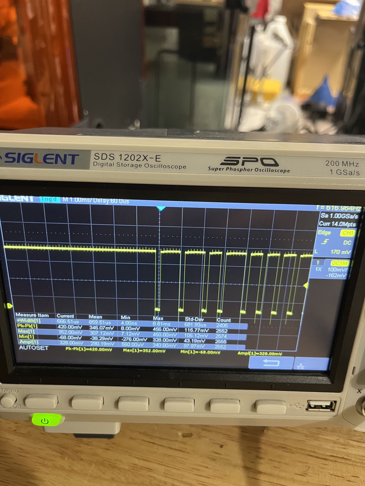 A PPM frame on the Siglent oscilloscope: the sync gap followed by the channel pulses, with pulse-width measurements on screen.